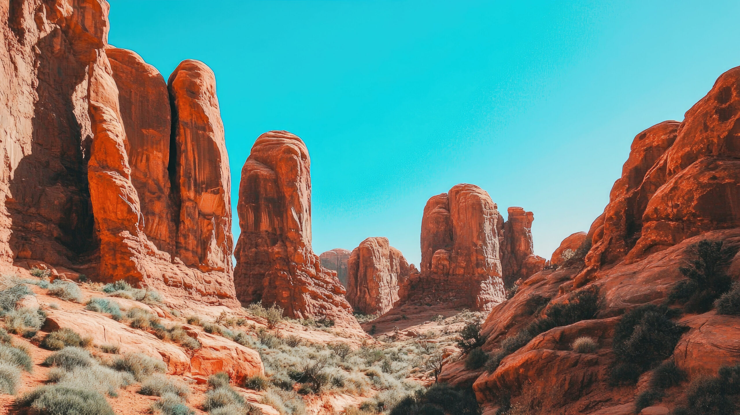 Red rock formations at Arches National Park, clear blue skies, open area for text overlay